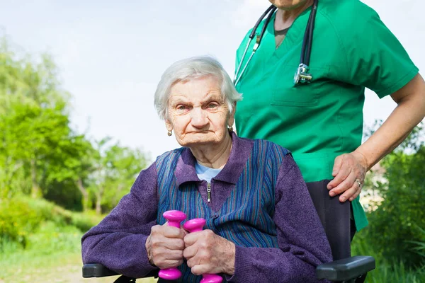 Behinderte Ältere Frau Sitzt Rollstuhl Mit Lächelndem Hausmeister Freien — Stockfoto