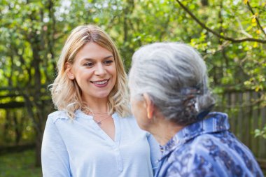 Yaşlı kadın bahçede - tıbbi bakım ile yürüme dostu caregiver