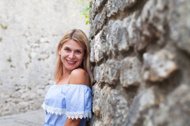 Kameraya gülümseyen mavi elbiseyle büyüleyici genç bir Bayan portresi