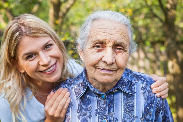 Ελκυστική Νεαρή Γυναίκα Αγκαλιάζοντας Παλιά Γιαγιά Εξωτερική Θηλυκό Γενεών Αγάπη — Φωτογραφία Αρχείου
