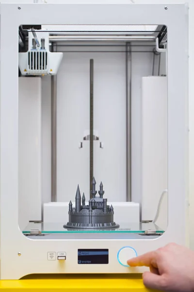 White 3D printer during work. Plastic castle - disney figure almoust done