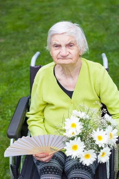 Behinderte Ältere Frau Sitzt Rollstuhl Und Erhält Einen Blumenstrauß Zum — Stockfoto