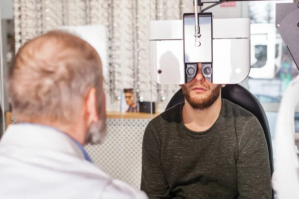 Oogarts Onderzoekt Jongeman Met Optometric Machine Optica Winkel — Stockfoto