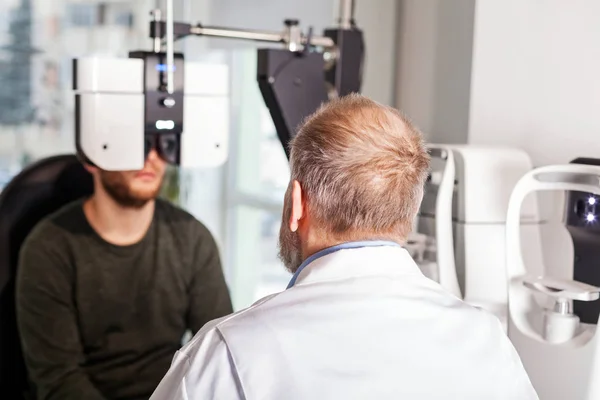 Oftalmologista Examinando Jovem Com Máquina Optométrica Loja Óptica — Fotografia de Stock