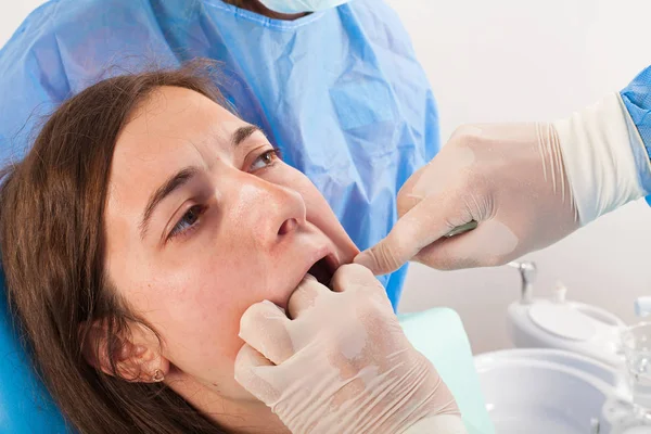 Surgeon removing the wisdom tooth with his assistant