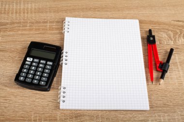 Sayaç, kalem, defter, pergel - okul ve ofis malzemeleri ahşap arka plan üzerinde