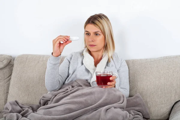 Sick Woman Sitting Couch Wrapped Warm Blanket Holding Hot Tea — Stock Photo, Image