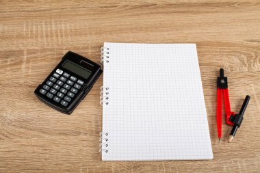 Sayaç, kalem, defter, pergel - okul ve ofis malzemeleri ahşap arka plan üzerinde