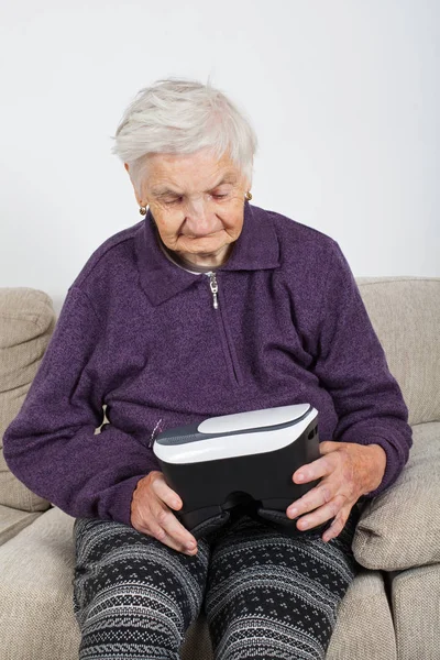 老年退休妇女体验虚拟现实视频与耳机 — 图库照片