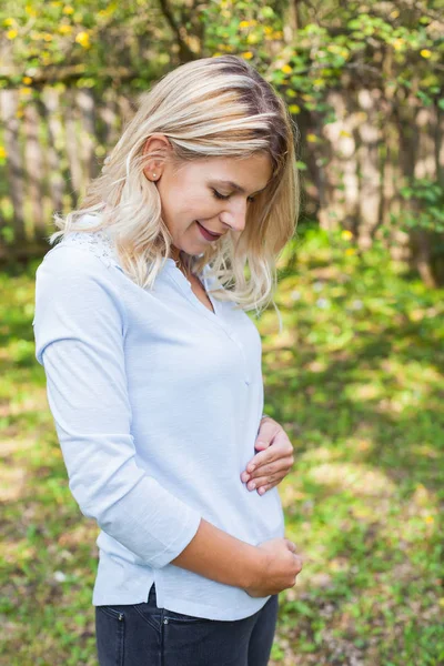 Nádherná Mladá Žena Drží Její Bříško Zahradě První Trimestr Těhotenství — Stock fotografie