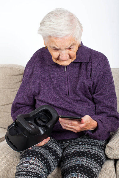 Elderly retired woman experiencing virtual reality video with headset