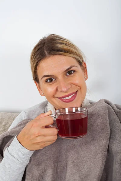Chory Młoda Kobieta Odpoczynku Kanapie Picie Gorącej Herbaty Trzymając Serwetki — Zdjęcie stockowe