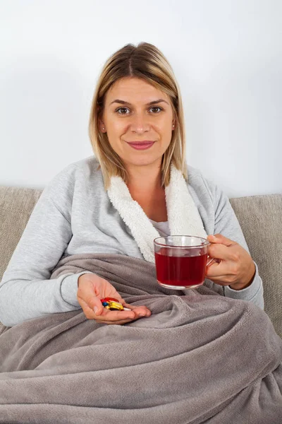 Mujer Joven Enferma Acostada Sofá Caliente Medicamentos Pañuelos Sonriendo Cámara —  Fotos de Stock