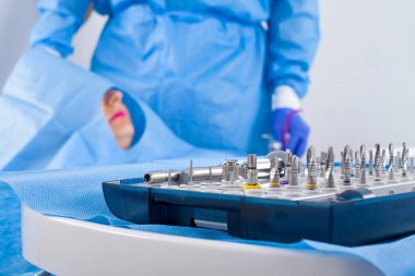 Dişçi diş implantı ameliyat mavi üniformalı