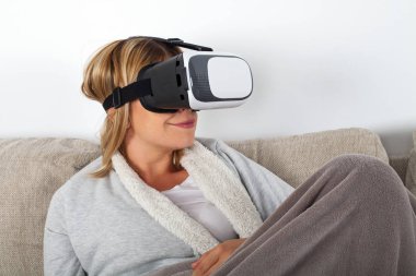 Kanepede dinlenirken kulaklık ile bir 3d sanal gerçeklik video izlerken kadın