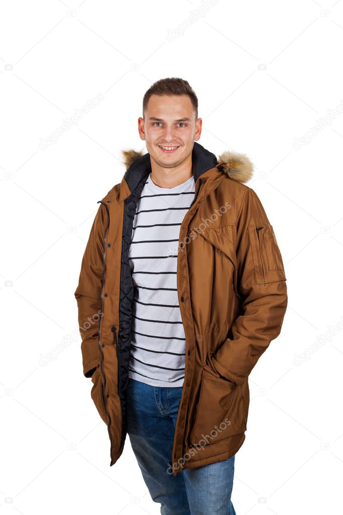 Handsome young man wearing a light brown winter parka jacket - smiling to the camera on isolated background