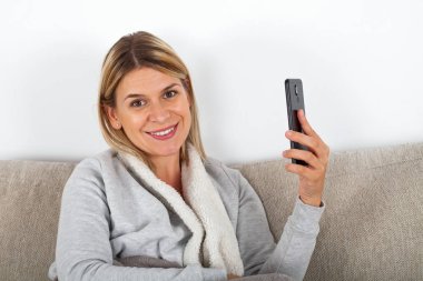 Video aramasý bir arkadaşıyla evde kanepede dinlenirken sahip çekici genç kadın