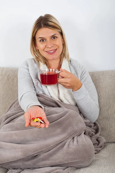 陽気な若い女性はソファでリラックス 熱いお茶を飲むと友人と電話で話して — ストック写真