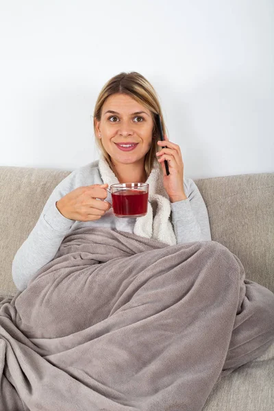 Veselá Mladá Žena Odpočinku Pohovce Pití Horkého Čaje Mluví Telefonu — Stock fotografie