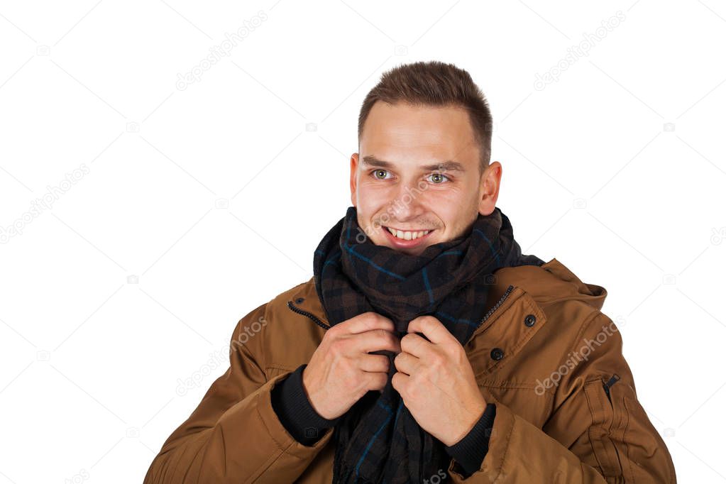 Handsome young man wearing a light brown winter parka jacket - smiling to the camera on isolated background