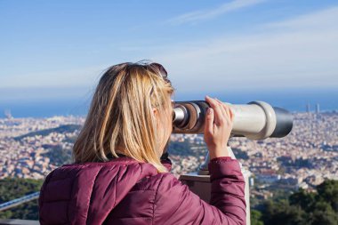 Sarışın kadın turist Tibidabo - panoramik manzaralı Barcelona, Catalunia üst kısmında dürbün arıyorum