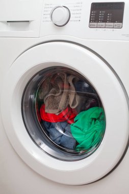 Modern otomatik çamaşır makinesi renkli giysileri ile yüklü