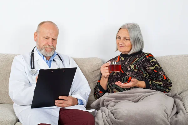 Arzt Mit Klemmbrett Diagnostiziert Einen Älteren Patienten Hause — Stockfoto