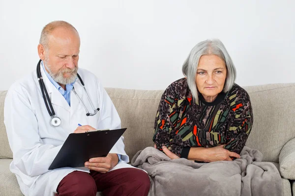 Arzt Mit Klemmbrett Diagnostiziert Einen Älteren Patienten Hause — Stockfoto