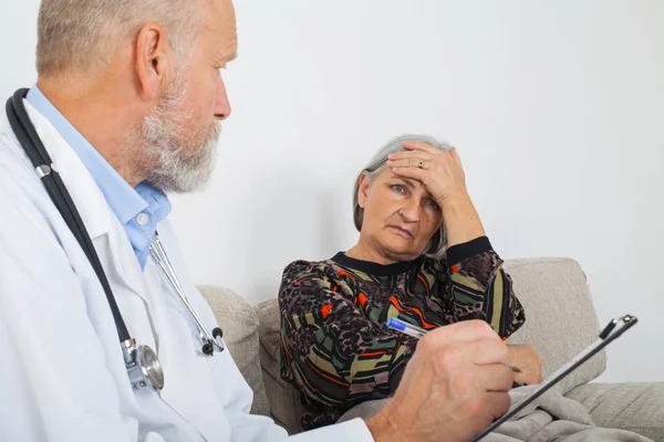 Arts Met Klembord Diagnose Van Een Oudere Patiënten Thuis — Stockfoto