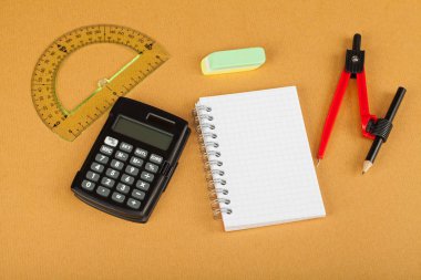 Öğrenme araçları - defter, kalem, makas, hesap makinesi, cetvel, vb - ahşap arka plan üzerinde okul
