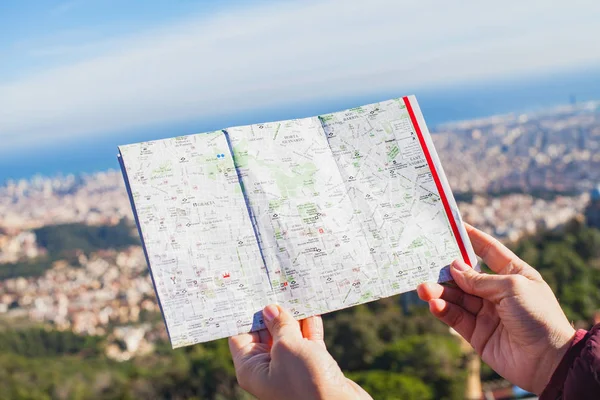 Female tourist searching for the right direction in the city map in Barcelona, Catalonia