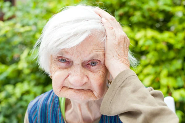 一名老年妇女触摸头部的照片 — 图库照片