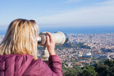 Sarışın kadın turist Tibidabo - panoramik manzaralı Barcelona, Catalunia üst kısmında dürbün arıyorum