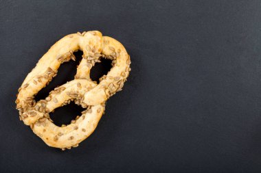 Taze pişmiş lezzetli çıtır twist ile siyah arka plan ayçiçeği tohumu