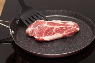 Bir yapışmaz tavada indüksiyon ocakta bir güzel Çiğ domuz biftek resmini kapatın