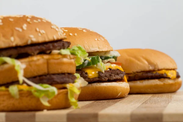 Tres Tipos Tamaños Diferentes Deliciosas Hamburguesas Tablero Madera —  Fotos de Stock