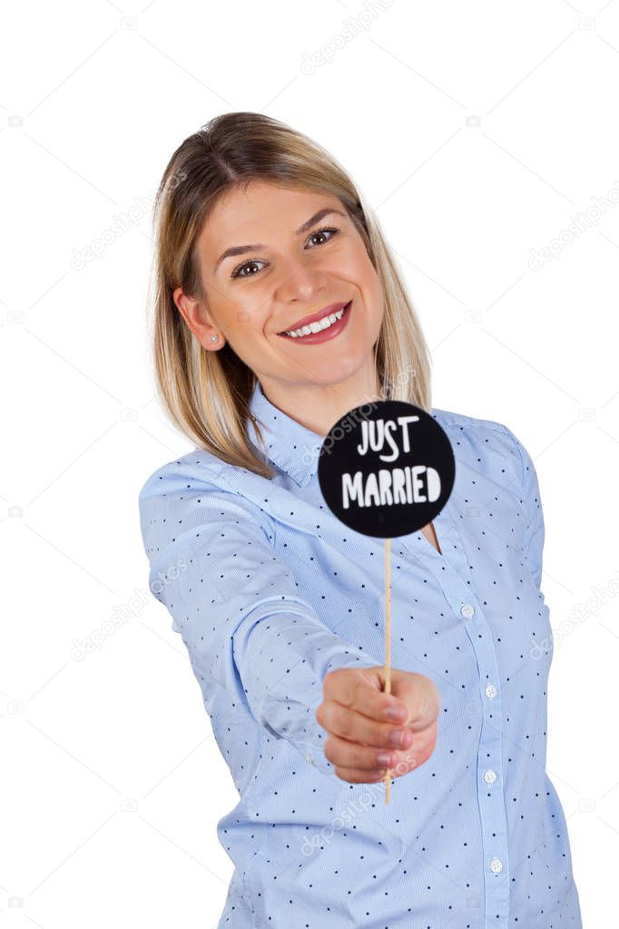 Attractive young woman holding photo booth accessories with Just Married text is smiling to the camera on isolated