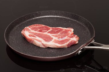 Bir yapışmaz tavada indüksiyon ocakta bir güzel Çiğ domuz biftek resmini kapatın