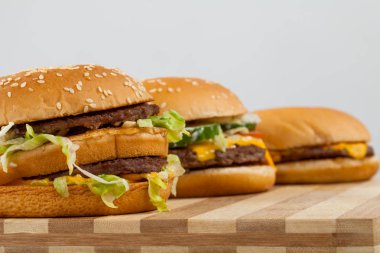 Üç farklı türü ve boyutu bir ahşap tahta üzerinde lezzetli burger
