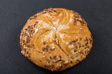 Fırından yeni çıkmış bütün tahıl topuz tohumları üstte - siyah arka plan ile