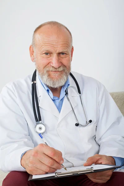Succesvolle Senior Mannelijke Arts Medische Diagnose Formulier Invult Zittend Een — Stockfoto