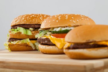 Üç farklı türü ve boyutu bir ahşap tahta üzerinde lezzetli burger