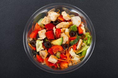 Siyah arka plan üzerine bir kase içinde organik sebze taze lezzetli tavuk salatası