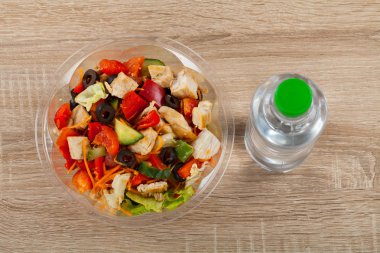 Bir kase ve durgun su ahşap arka plan üzerinde organik sebze taze lezzetli tavuk salatası