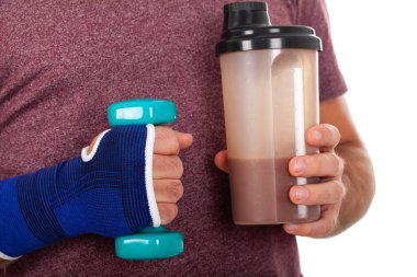 Genç bir adam bir dumbbell ve süt Holding'in resmi oluşturan kapatın