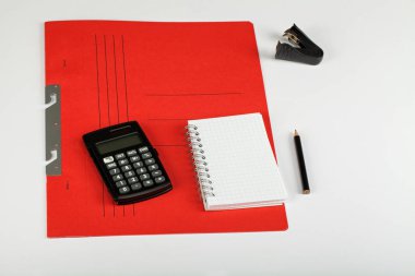 Sayaç, kalem, defter, kırmızı portföy - beyaz arka plan üzerinde okul ve ofis malzemeleri