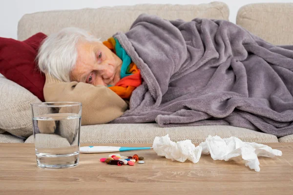 Старшая Женщина Чувствует Себя Плохо Лежит Диване Завернутый Одеяло Грипп — стоковое фото