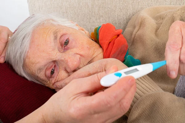 Sick elderly woman on the sofa — Stock Photo, Image