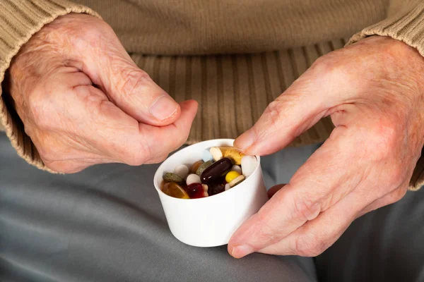 Elderly hands holding pills — Stock Photo, Image