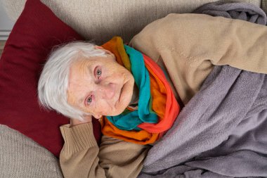 Yaşlı kadın kanepede yalan